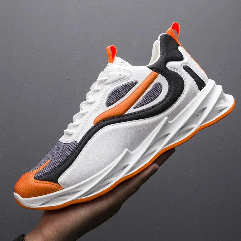 White, orange, and black sneaker held by a hand against a dark background
