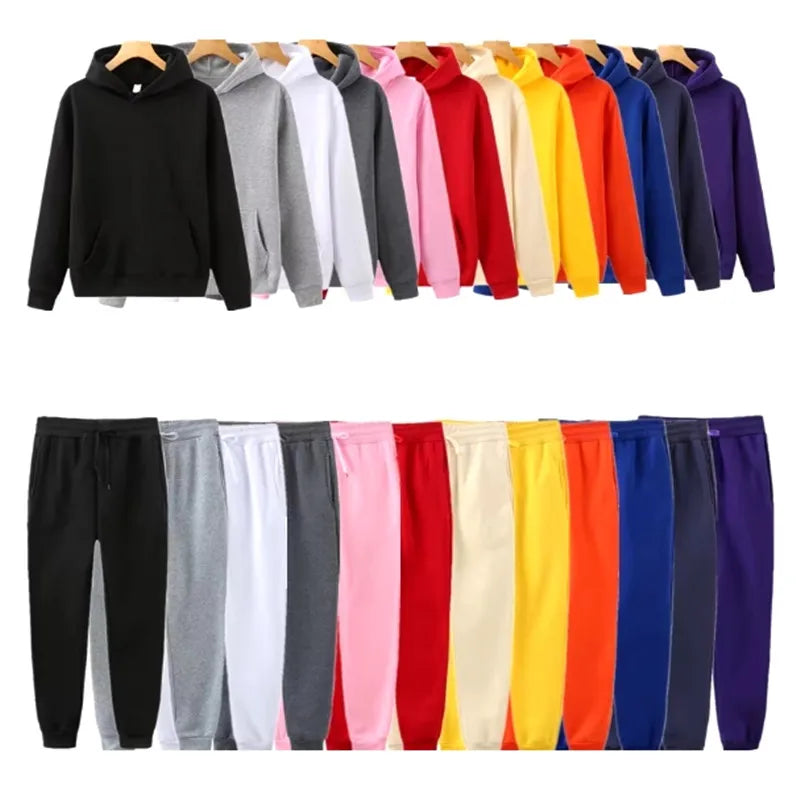 Row of colorful hoodies and pants on hangers against a white background