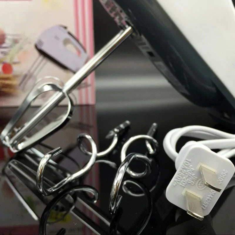 Close-up of a hair dryer and various attachments on a reflective surface.