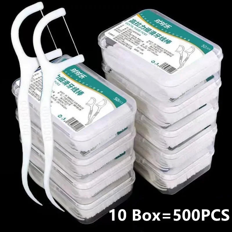 Stack of dental floss boxes with a white floss holder on a black background