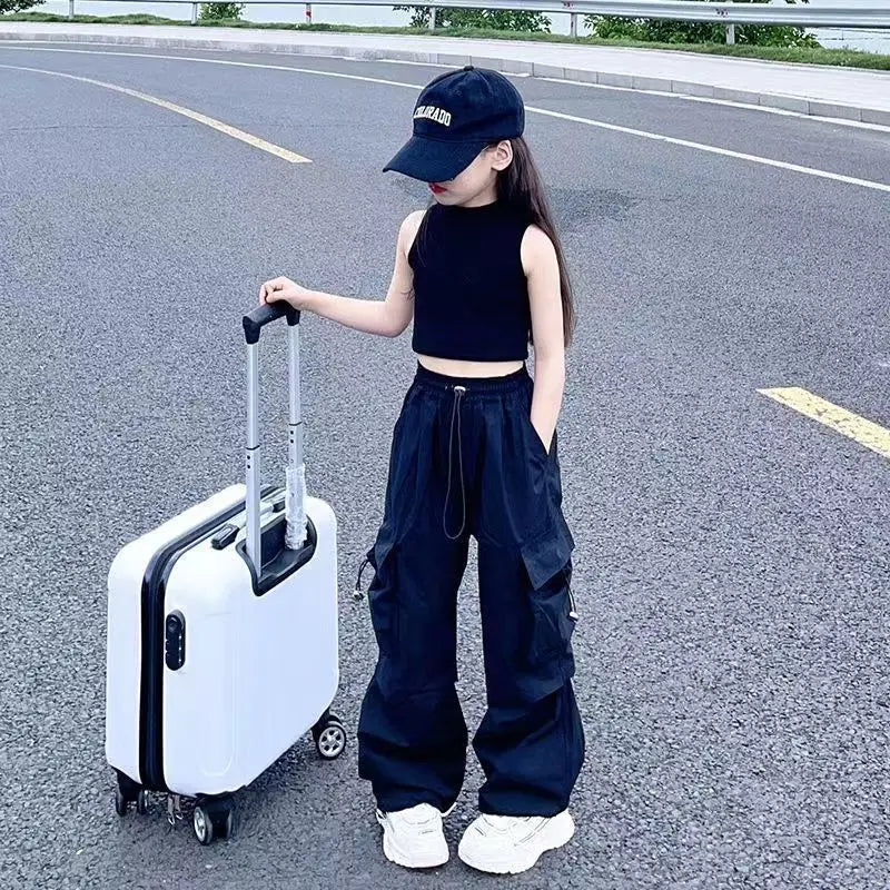 Person in black outfit with a white suitcase on a road