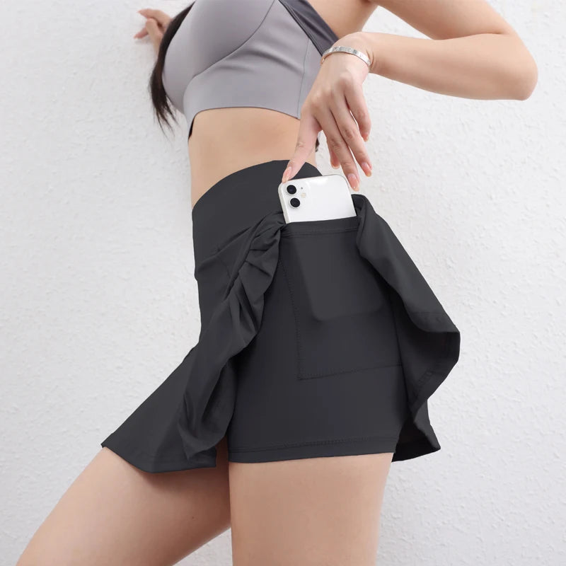 Person wearing black shorts with a pocket holding a phone on a light gray background