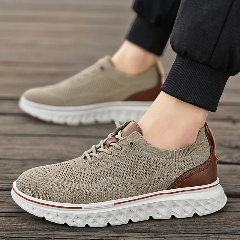 Beige and brown sneakers with white soles on a wooden floor.