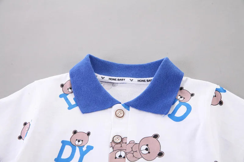 Children's polo shirt with blue collar and bear designs on a gray background