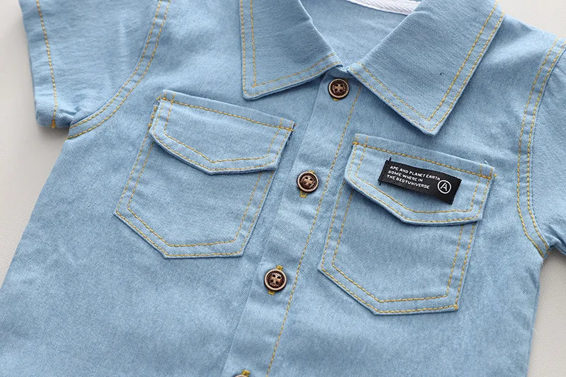 Close-up of a light blue denim shirt with button details on a neutral background