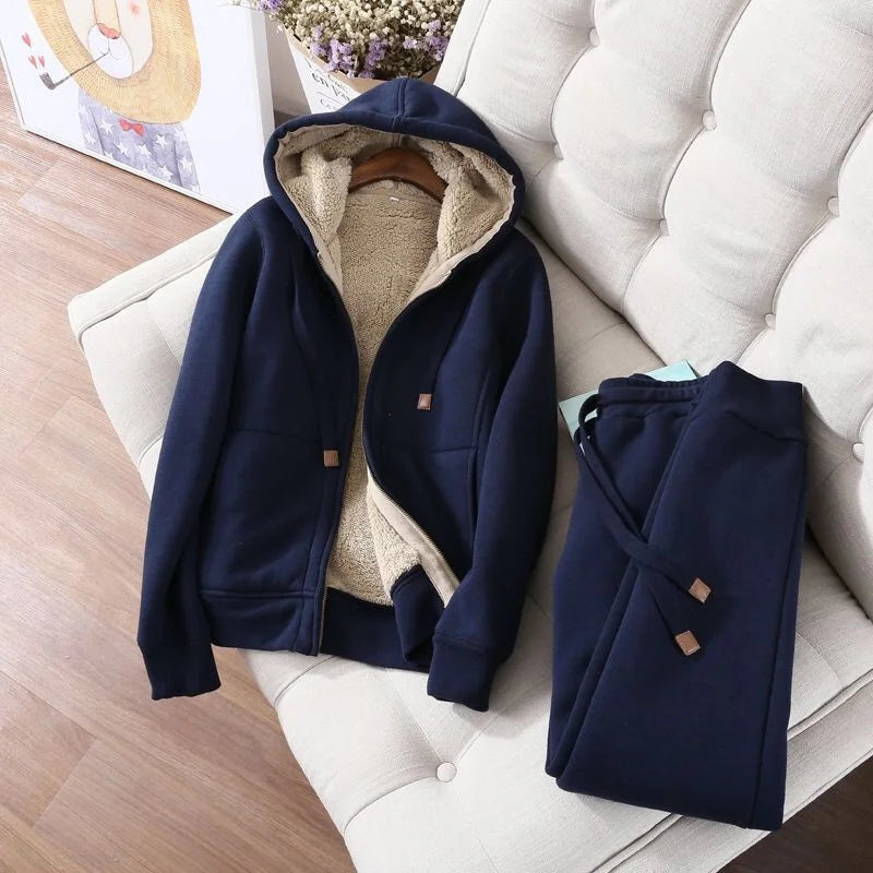 Navy blue jacket and coat on a white chair with a wooden floor and decorative items in the background.
