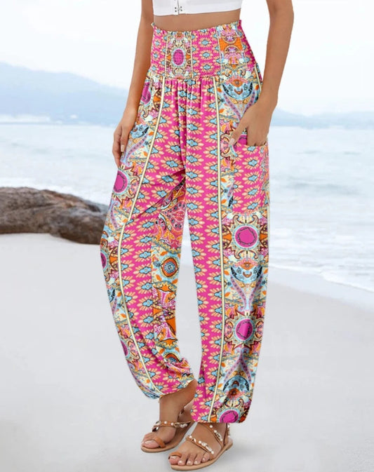 Colorful patterned pants worn by a person on a beach.