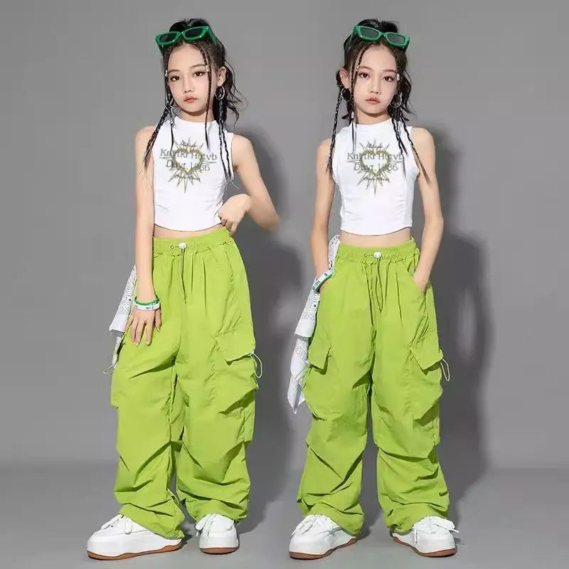 Two identical images of a girl wearing a white crop top and green pants on a gray background.