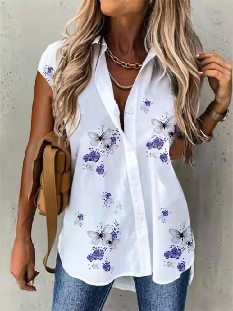 Woman wearing a white blouse with butterfly and floral patterns, holding a brown bag.