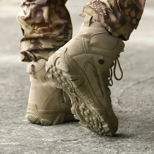 Tan tactical boots with camouflage pants on a concrete surface