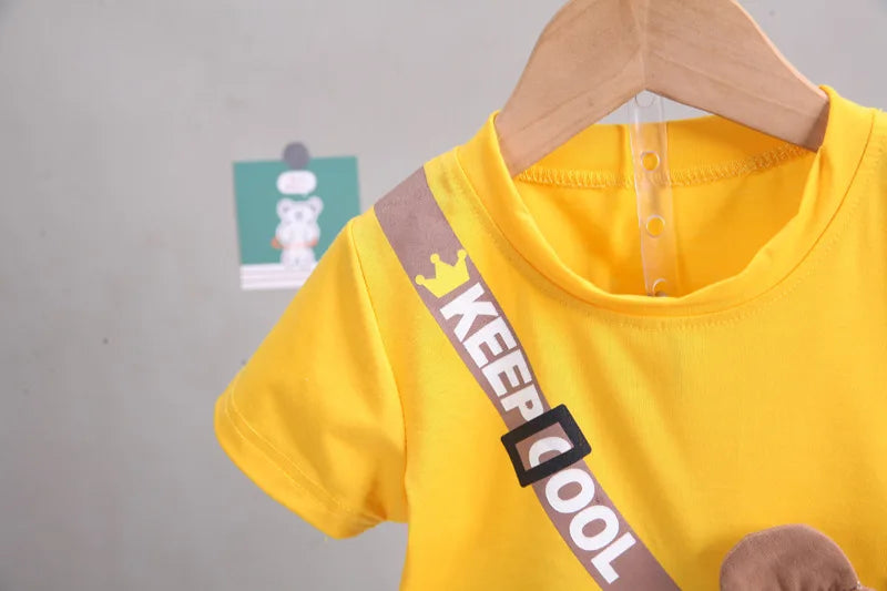 Yellow t-shirt with 'KEEP COOL' strap on a hanger against a gray background