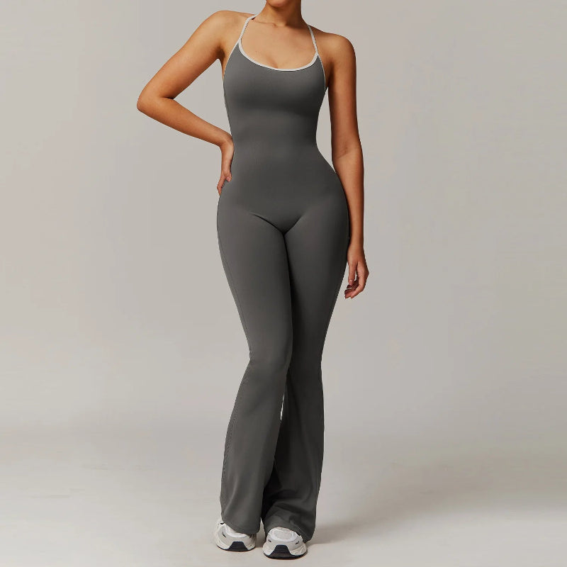 Woman wearing sleeveless V-back workout jumpsuit in a yoga pose with sporty background