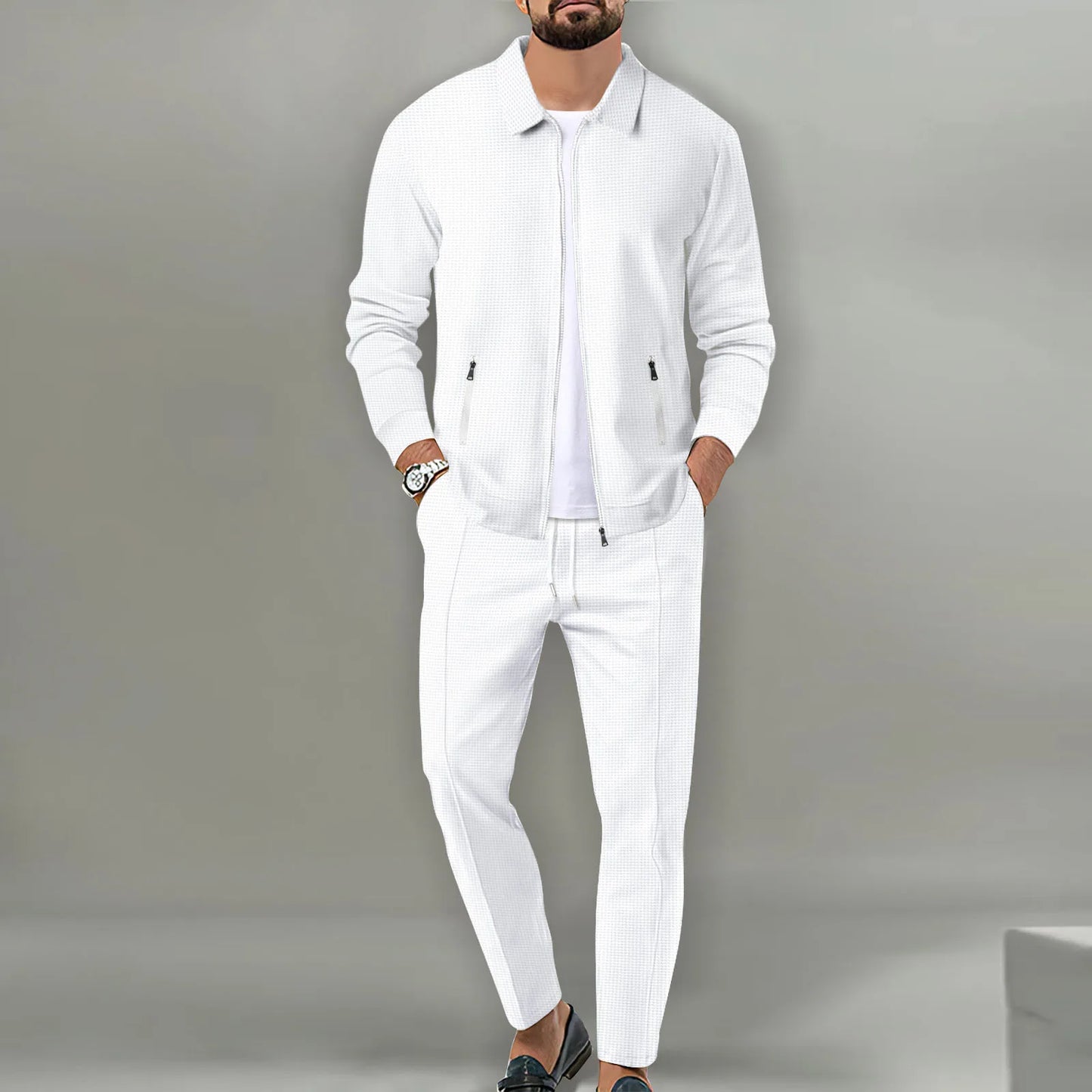 Man wearing a white outfit against a gray background