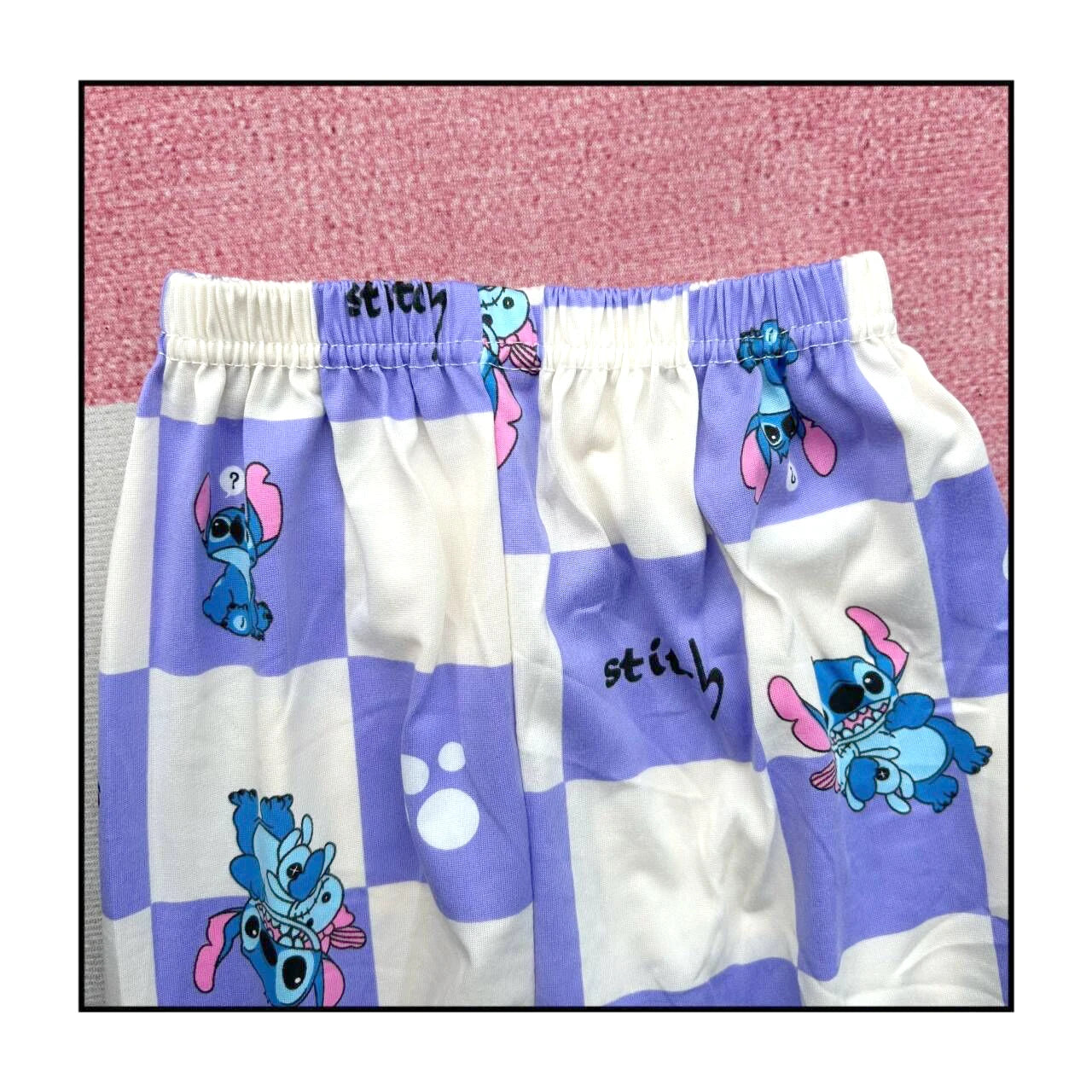 Checkered shorts with cartoon character design on a pink background