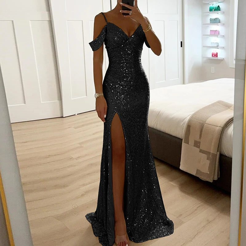 Black sequin evening gown with a high slit worn by a person in a bedroom setting.