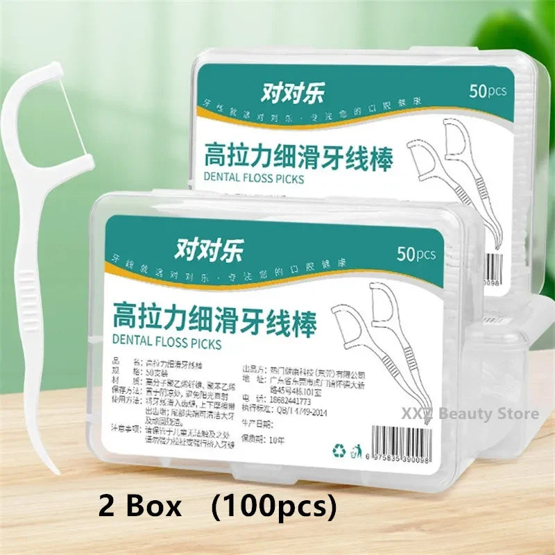 Two boxes of dental floss picks with packaging labels on a wooden surface.