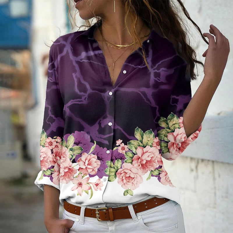 Woman wearing a purple floral blouse with a blurred background