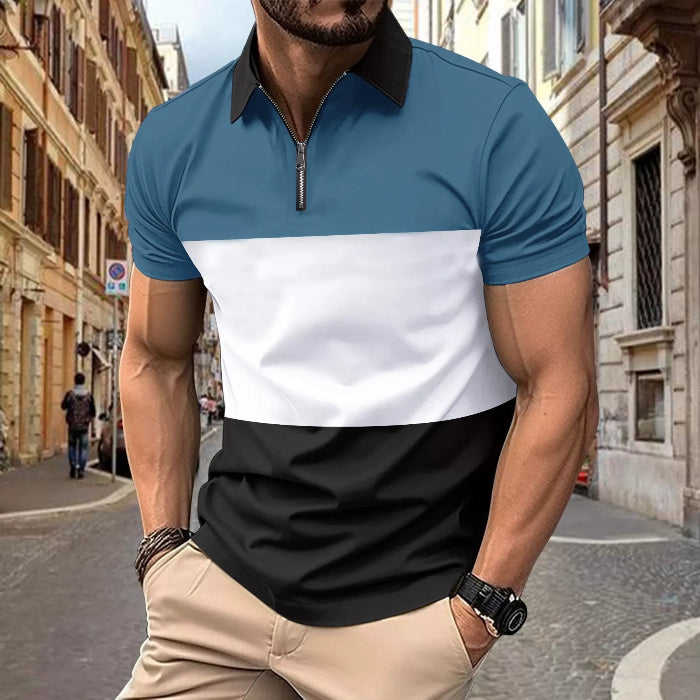 A man wearing a color-blocked polo shirt with a white collar, blue chest panel, and black bottom. The shirt has short sleeves and a zipper at the chest.