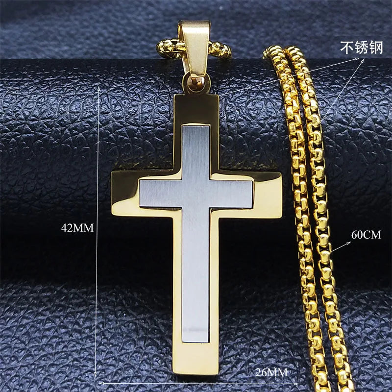 Gold cross pendant and chain on a textured black surface