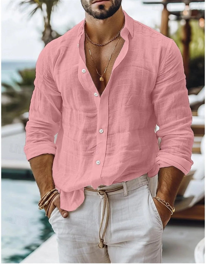 Man wearing a pink linen shirt and light-colored pants by a poolside.
