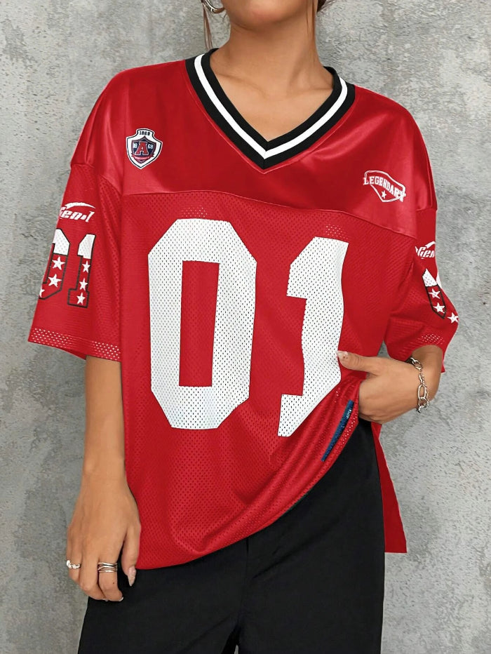 A woman wearing a black V-neck sports jersey with the number '01' on it. The jersey has white text and trim, and it appears to be made of polyester fabric.