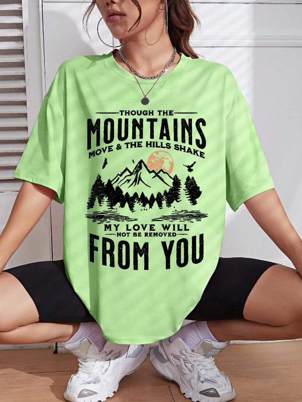 Person wearing a light green t-shirt with a mountain graphic and text.