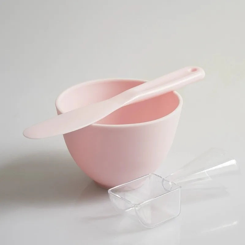 Pink bowl with a matching spoon on a light gray background