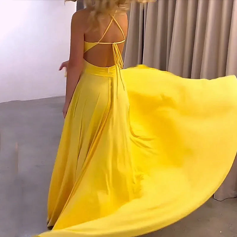Yellow dress with a flowing skirt in front of a neutral background