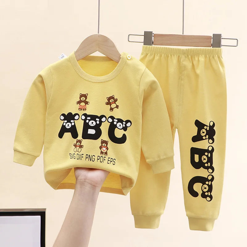 Toddler wearing a soft cotton Minnie-themed top and pants set, smiling in a sunny park with spring flowers around yellow