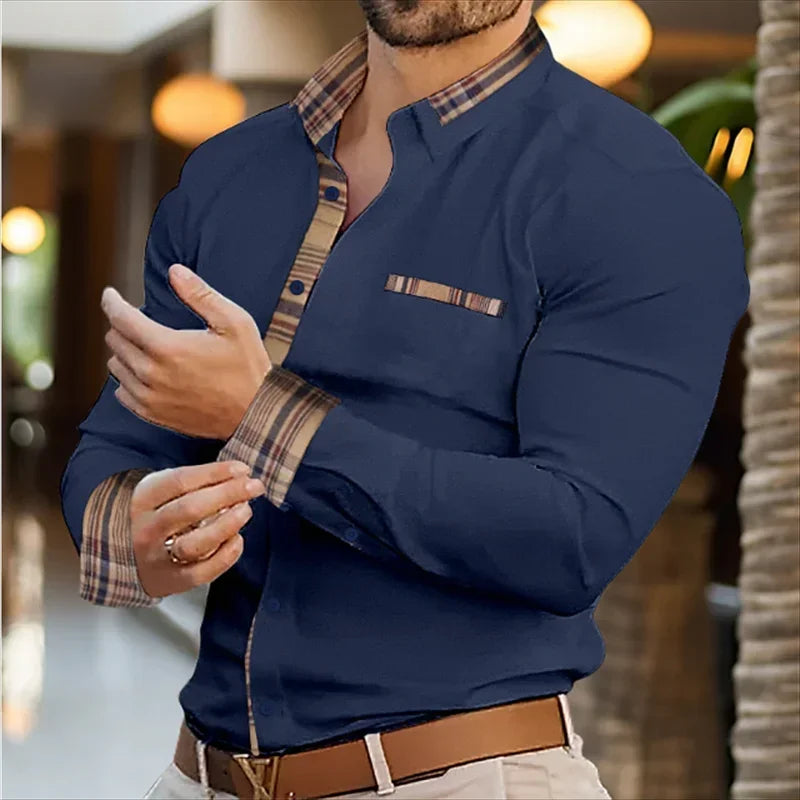 Man wearing a navy blue shirt with plaid accents in an indoor setting