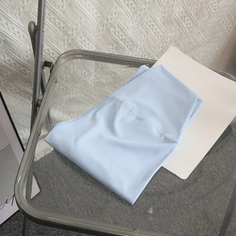 Light blue towel on a glass table with a textured wall background