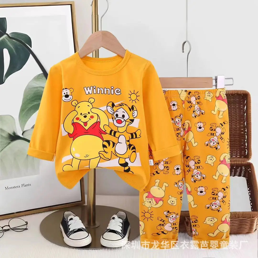 Children's pajama set with Winnie the Pooh and Tiger design on a hanger.
