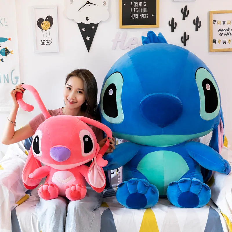 Person holding a pink plush toy and a large blue plush toy in a room with decorative elements.