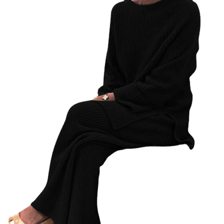 Person wearing a black outfit sitting on a white background