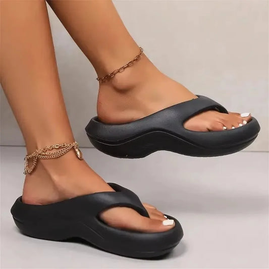 Black sandals worn on feet with a neutral background