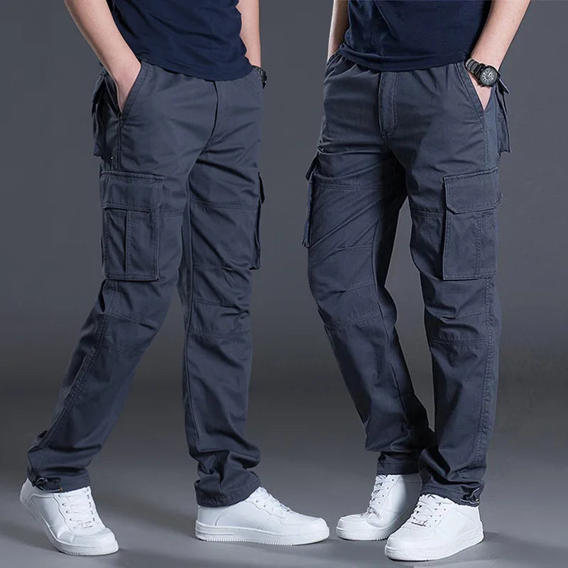 Two people wearing dark cargo pants and white sneakers on a gray background