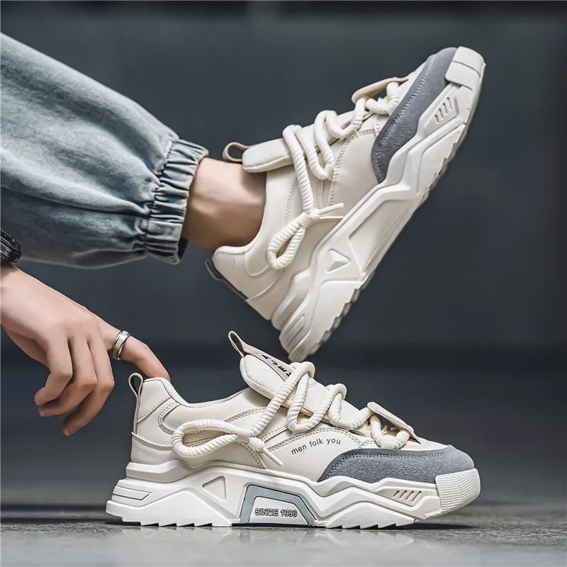 White and gray sneakers with a person wearing one, on a dark background