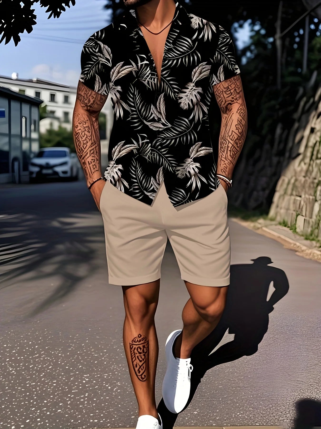 Person wearing a black and white floral shirt with beige shorts on a street.
