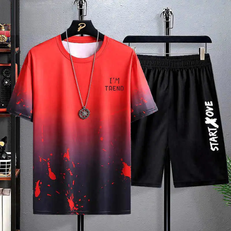 Red and black gradient t-shirt with text and black shorts on hangers against a gray background