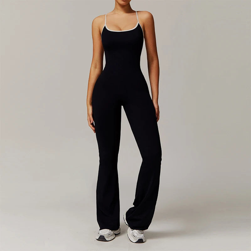 Person wearing a black jumpsuit with a white top on a plain background