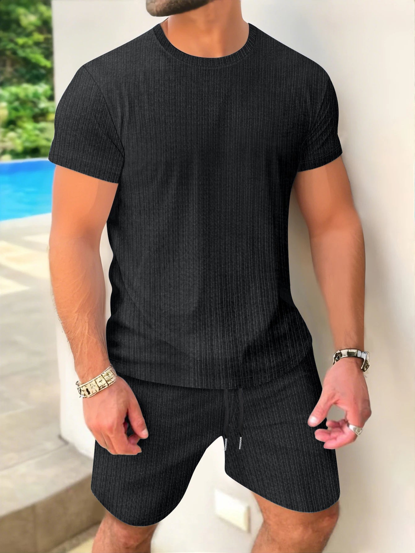 Person wearing a black ribbed t-shirt and shorts with a blurred background