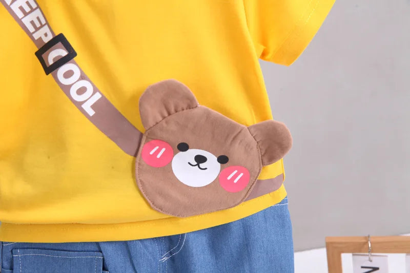Person wearing a yellow shirt with a cartoon bear-shaped pouch on a plain background