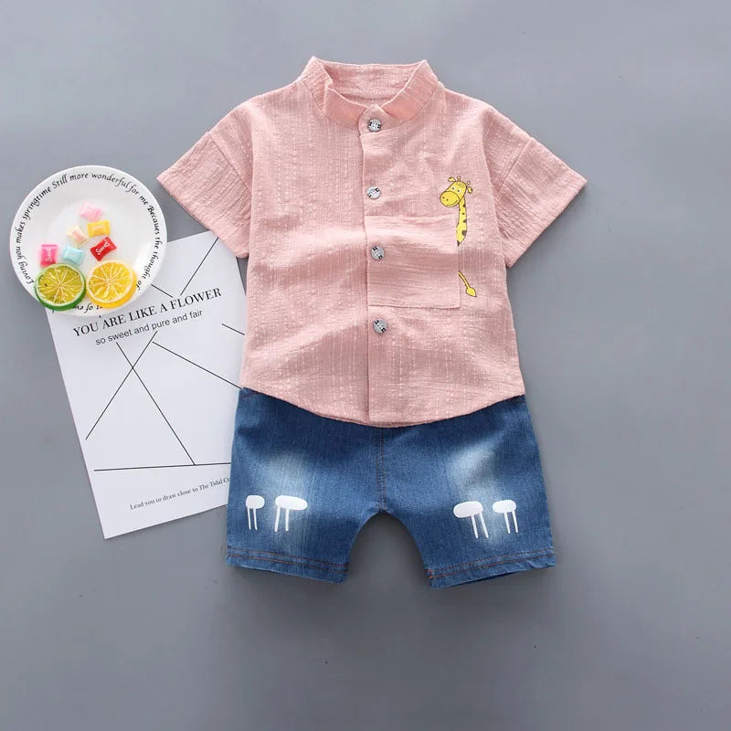Children's outfit with pink shirt and blue shorts on a gray background