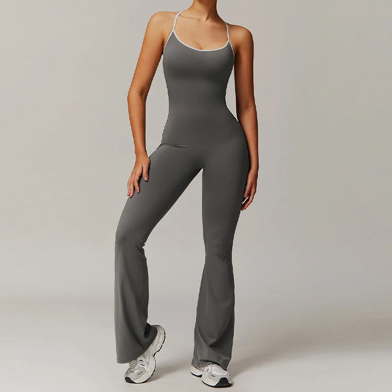 Woman wearing sleeveless V-back workout jumpsuit in a yoga pose with sporty background
