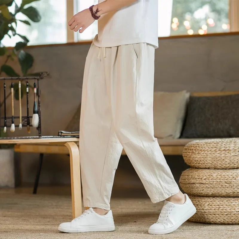 Person wearing beige pants and white sneakers in a home setting