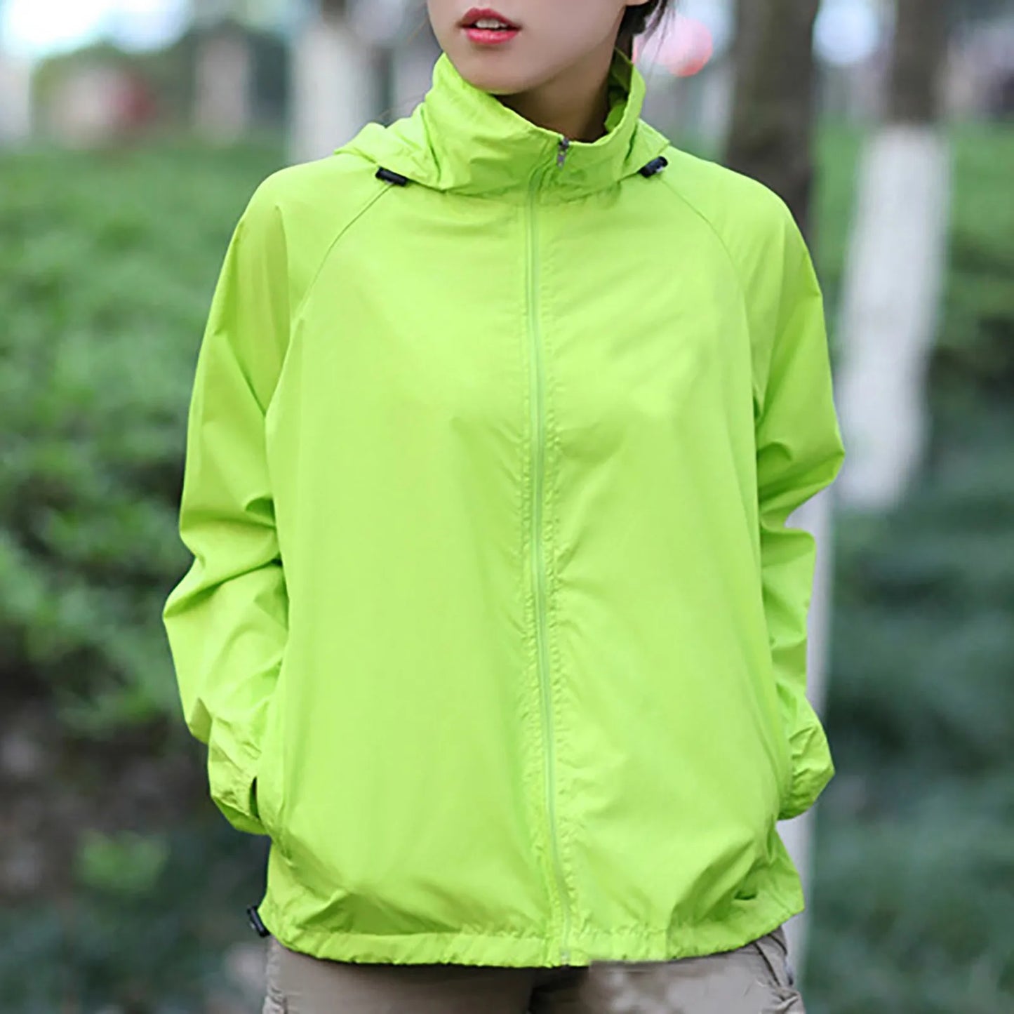 Person wearing a bright green jacket outdoors with a blurred background