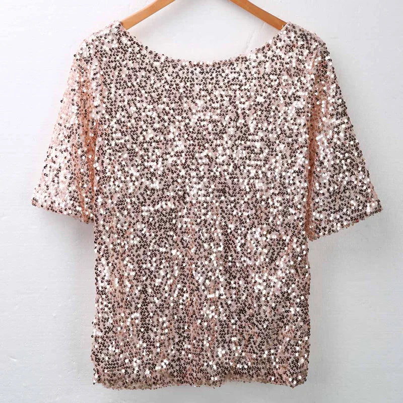 Rose gold sequin top on a hanger against a white background