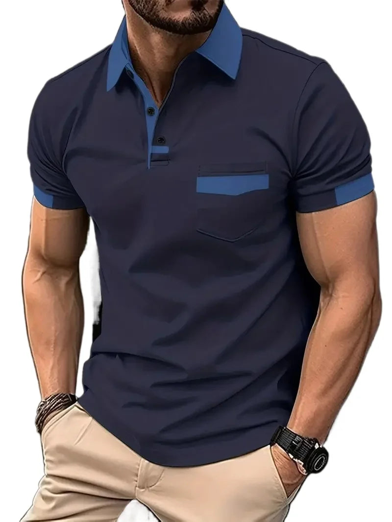A man wearing a short-sleeved beige polo shirt with blue collar and pocket trim, and light beige shorts.