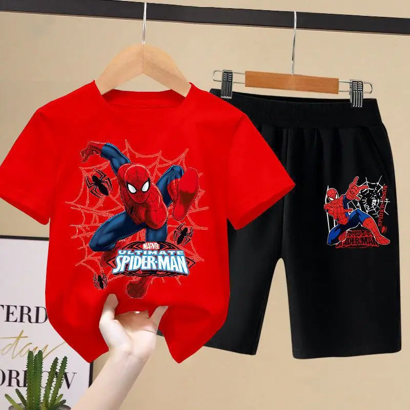 Red t-shirt and black shorts with Spider-Man design on hangers against a beige wall.