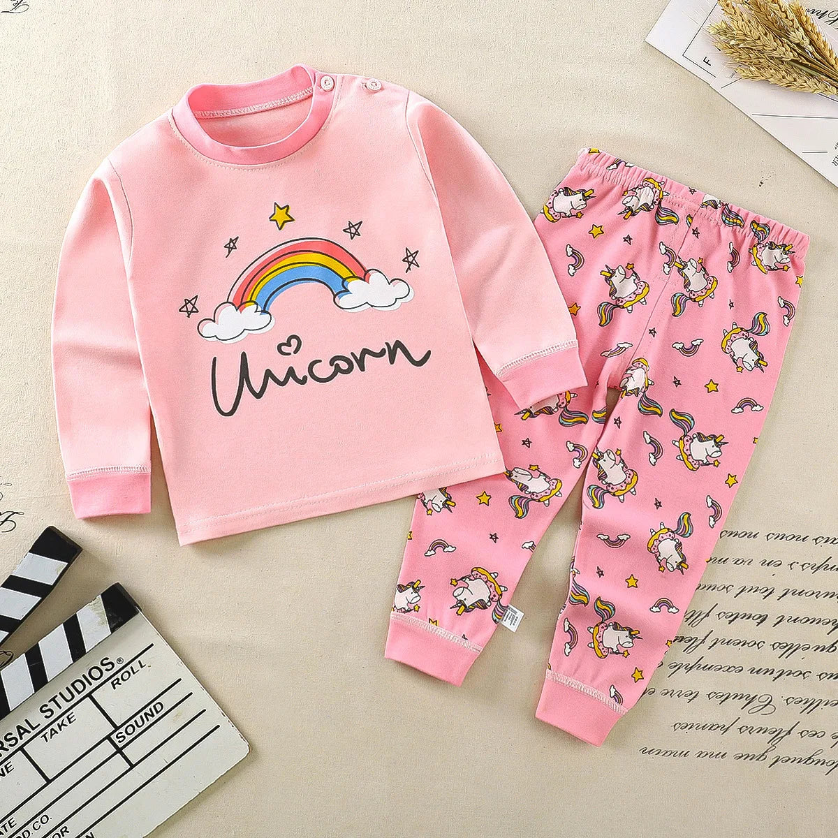 A baby girl's outfit set with long sleeves, featuring Minnie Mouse character designs, hanging on a wooden hanger.